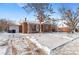 Brick ranch house with snowy yard, front view at 1435 Quebec St, Denver, CO 80220