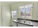 Kitchen features grey cabinets, double sink and backyard access at 1435 Quebec St, Denver, CO 80220