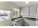 Galley kitchen with grey cabinets and double sink at 1435 Quebec St, Denver, CO 80220