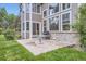 Backyard patio area includes a table, grill, brick, siding, and lush landscaping at 2215 Parkview Dr, Longmont, CO 80504