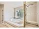 Bathroom showcasing a large bathtub beneath a window, and a separate glass shower enclosure with a built-in bench at 2215 Parkview Dr, Longmont, CO 80504