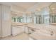 Spacious bathroom with dual sinks, a seated vanity area, and large mirrors reflecting ample natural light at 2215 Parkview Dr, Longmont, CO 80504