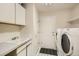 Well-lit laundry room features a sink, cabinetry, washer, and dryer at 2215 Parkview Dr, Longmont, CO 80504
