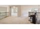 Open loft area with railing, piano and carpet; entry to bedroom visible in the background at 2215 Parkview Dr, Longmont, CO 80504