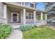 Inviting covered porch with white columns, brick accents, and a beautifully landscaped garden at 2215 Parkview Dr, Longmont, CO 80504