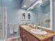 Modern bathroom featuring double sinks with granite countertops, a glass-enclosed shower, and a large mirror at 710 Kittredge St, Aurora, CO 80011