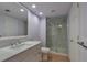 Well-lit bathroom with a large mirror, vanity sink, and a glass-enclosed shower featuring tiled walls and a shower niche at 710 Kittredge St, Aurora, CO 80011