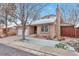 Inviting exterior of a brick home with an attached two car garage and snow dusted yard at 710 Kittredge St, Aurora, CO 80011