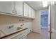 Functional laundry room featuring ample cabinet storage, a utility sink, and access to an additional bathroom at 710 Kittredge St, Aurora, CO 80011
