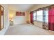 Bright living room with a large window adorned with floral curtains and neutral carpet, offering a cozy space at 710 Kittredge St, Aurora, CO 80011