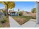 Large backyard with a grassy area, concrete pathways, and mature trees at 4922 Meade St, Denver, CO 80221