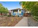 Charming bungalow with blue exterior, landscaped yard, and walkway at 4922 Meade St, Denver, CO 80221