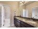 Bright bathroom features a double vanity with granite counters and framed mirrors at 853 Jenny Ln, Berthoud, CO 80513
