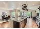 Open kitchen with granite island, stainless steel appliances, and hardwood floors at 853 Jenny Ln, Berthoud, CO 80513