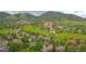 An aerial view shows a home located in a neighborhood next to a golf course and large mountains at 5569 Willow Springs Dr, Morrison, CO 80465