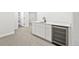 Basement featuring a sleek wet bar with modern cabinetry, a stainless steel beverage cooler, and neutral carpeting at 5569 Willow Springs Dr, Morrison, CO 80465