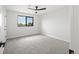 A simple bedroom with neutral colored carpet, walls and a modern ceiling fan at 5569 Willow Springs Dr, Morrison, CO 80465