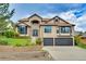 Charming two-story home with lush landscaping, brick facade, and attached two-car garage at 5569 Willow Springs Dr, Morrison, CO 80465