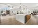 Open concept kitchen featuring a large center island, brick fireplace, and modern pendant lights at 5569 Willow Springs Dr, Morrison, CO 80465
