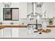 Modern kitchen with white subway tile backsplash, stainless steel hood, and quartz countertops at 5569 Willow Springs Dr, Morrison, CO 80465