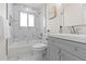 Modern bathroom features geometric tile, updated fixtures, and a tub with shower at 7961 Granada Rd, Denver, CO 80221