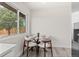 Bright dining area features a glass table and modern chairs by a sunlit window at 7961 Granada Rd, Denver, CO 80221