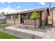 Inviting brick home with well-maintained landscaping, a covered porch, and a tidy walkway leading to the entrance at 7961 Granada Rd, Denver, CO 80221