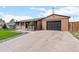 Charming one-story home featuring a detached garage with paved driveway and meticulously landscaped front yard at 7961 Granada Rd, Denver, CO 80221