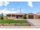 Lovely one-story home featuring manicured lawn, brick facade, and detached garage on a sunny day at 7961 Granada Rd, Denver, CO 80221