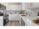 Charming kitchen with white cabinets, a farmhouse sink, and stainless steel appliances at 7961 Granada Rd, Denver, CO 80221