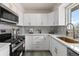 Kitchen boasts white cabinetry, stainless appliances, and stylish backsplash at 7961 Granada Rd, Denver, CO 80221