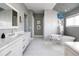 Bathroom featuring dual vanities, freestanding tub, and blue chandelier at 2409 S Fillmore St, Denver, CO 80210