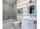 Bright bathroom featuring a tub, shower with glass enclosure, and modern fixtures at 2409 S Fillmore St, Denver, CO 80210