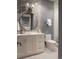 Modern bathroom featuring chevron tile, a round mirror, and marble countertop at 2409 S Fillmore St, Denver, CO 80210