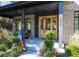 Inviting covered front entry featuring light brick, wood doors, and curated plantings at 2409 S Fillmore St, Denver, CO 80210