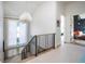 Bright hallway with modern railing, chandelier, and access to other rooms at 2409 S Fillmore St, Denver, CO 80210