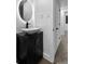 Stylish bathroom featuring a vessel sink with modern faucet, dark vanity, and round mirror at 3220 W 8Th Ave, Denver, CO 80204
