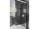Stylish bathroom featuring black tiled shower with glass door and tiled niche at 3220 W 8Th Ave, Denver, CO 80204