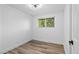 This is a clean bedroom with wood-look floors, featuring a ceiling fan, window, white walls and baseboards at 3220 W 8Th Ave, Denver, CO 80204