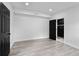 Expansive bedroom with laminate flooring, white walls, a connecting bathroom, and black doors at 3220 W 8Th Ave, Denver, CO 80204