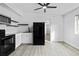 Modern kitchen featuring white cabinets, black hardware and appliances, and laminate floors at 3220 W 8Th Ave, Denver, CO 80204