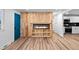 A modern living room boasts a fireplace, wooden wall, new vinyl flooring, and access to the kitchen at 3220 W 8Th Ave, Denver, CO 80204