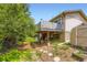 Backyard featuring a two-tiered deck with stairs, a storage shed, and mature trees at 3235 S Newland St, Denver, CO 80227
