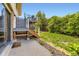 Backyard featuring an upper deck with stairs, a lower patio, and lush greenery at 3235 S Newland St, Denver, CO 80227