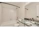 Bathroom with white tiled shower and bathtub, toilet, and granite countertop vanity with faucet and mirror at 3235 S Newland St, Denver, CO 80227