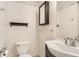 Cozy bathroom featuring a modern vanity, dark wood accents, and a toilet with a matching dark wood shelf at 3235 S Newland St, Denver, CO 80227