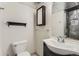 Bathroom featuring a white toilet, modern sink, and a dark tiled shower at 3235 S Newland St, Denver, CO 80227