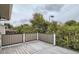 Outdoor deck with grey wood flooring and black metal railing, offering neighborhood views at 3235 S Newland St, Denver, CO 80227