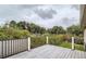 Outdoor deck with grey wood flooring and black metal railing, offering backyard views at 3235 S Newland St, Denver, CO 80227