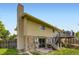 Back exterior featuring a chimney, two-tiered deck, and a well-maintained yard at 3235 S Newland St, Denver, CO 80227